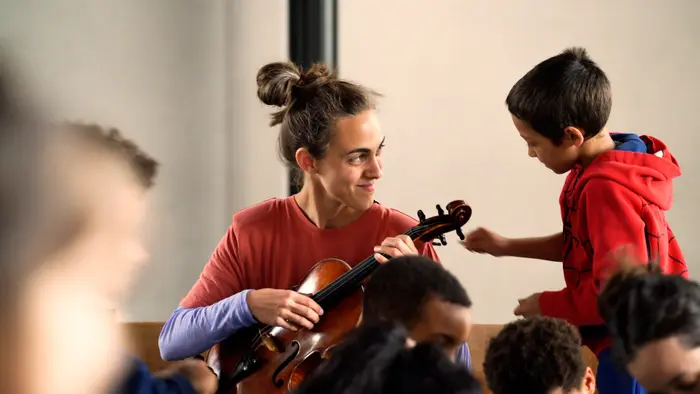 Sur ces images on voit Nina Vallon qui joue de l'alto en compagnie d'enfants.
