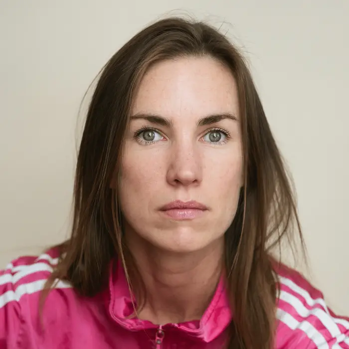Sur cette image apparaît Laureline Le Bris-Cep. Elle a les cheveux blonds, longs et lisses et porte une veste Adidas rose. Elle a les yeux bleus.