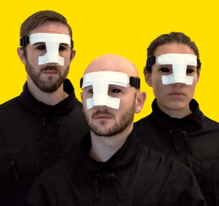 Portrait de 3 personnes qui ont un cache nez. On ne voit que leur visage et le haut du buste. Ils sont vêtus de sweat noirs et portent des lentilles noires qui recouvrent les yeux.