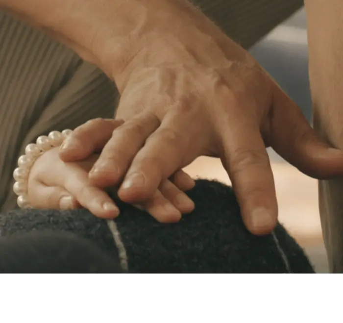 Sur cette image on voit deux mains qui se touchent, une d'entre elles est celle d'un enfant, l'autre est celle d'un adulte. On devine que ces mains sont posées sur un coussin galet.